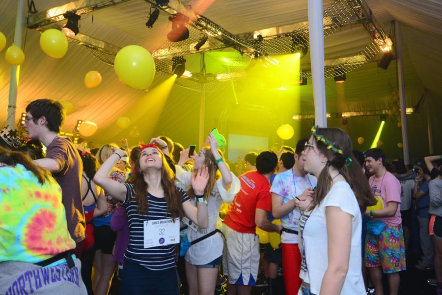 ​Dancers watch balloons fall inside the tent while the sun rises outside Saturday. After sunrise, students left the tent to run around Norris University Center to end Block 4.