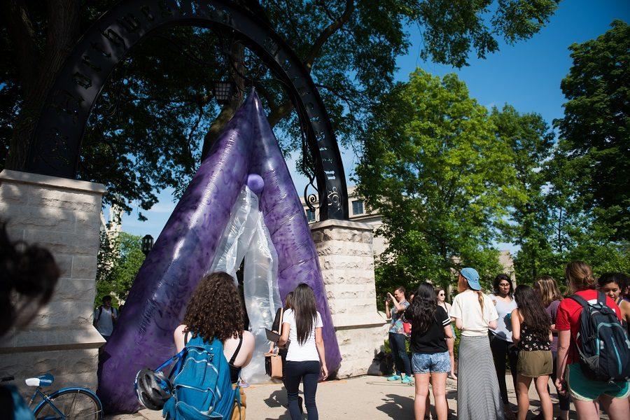 Student organizers hung a purple inflatable vulva at The Arch Friday afternoon. Spectators crowded around the piece, entitled PUSSYGATE.