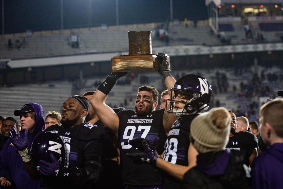 Joe Gaziano lifts the Hat trophy after Northwestern’s 2018 win over Illinois. The senior has been one of NU’s most productive players during his career in Evanston.
