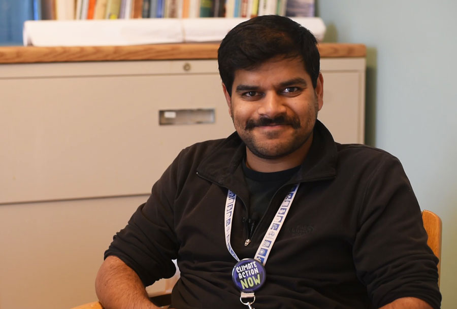 Kumar Jensen in a black shirt sitting in a chair.