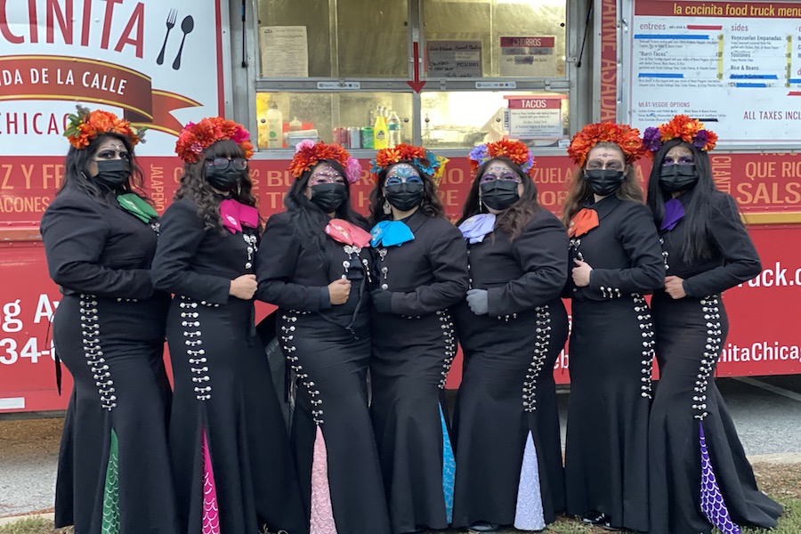  Mariachi Sirenas band members pose in front of La Cocinita food truck at Sunday’s Day of the Dead celebration in James Park Soccer Field.