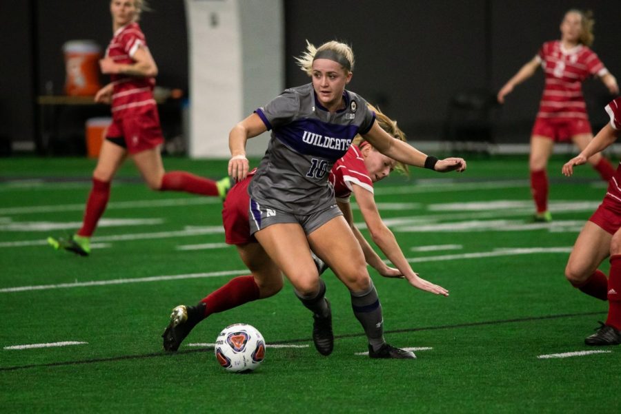 Women's soccer player dribbles with the ball.