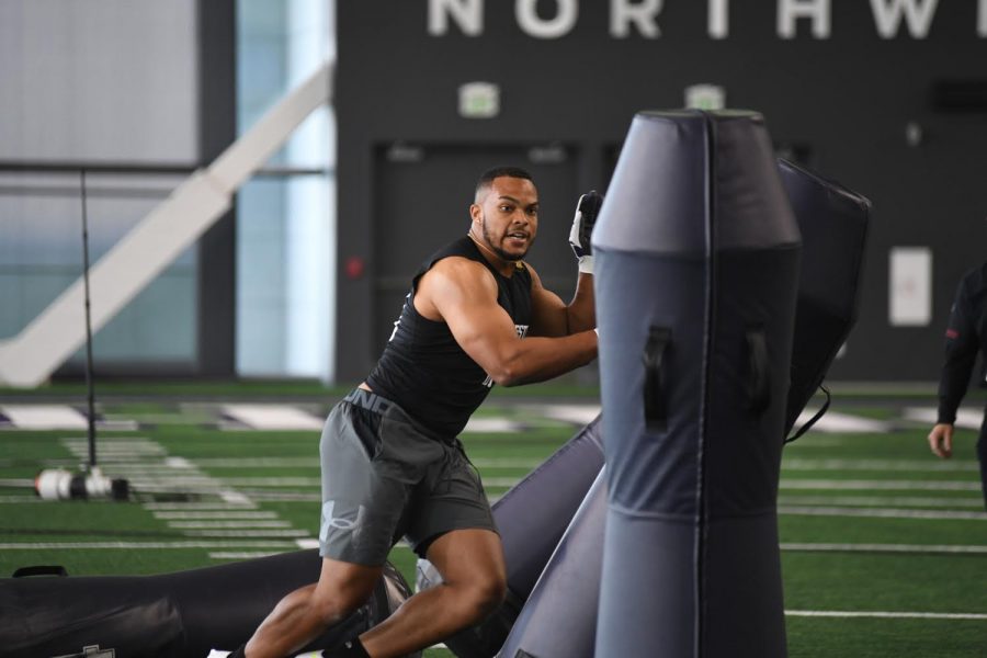 Northwestern football player hits beams as part of a football drill.