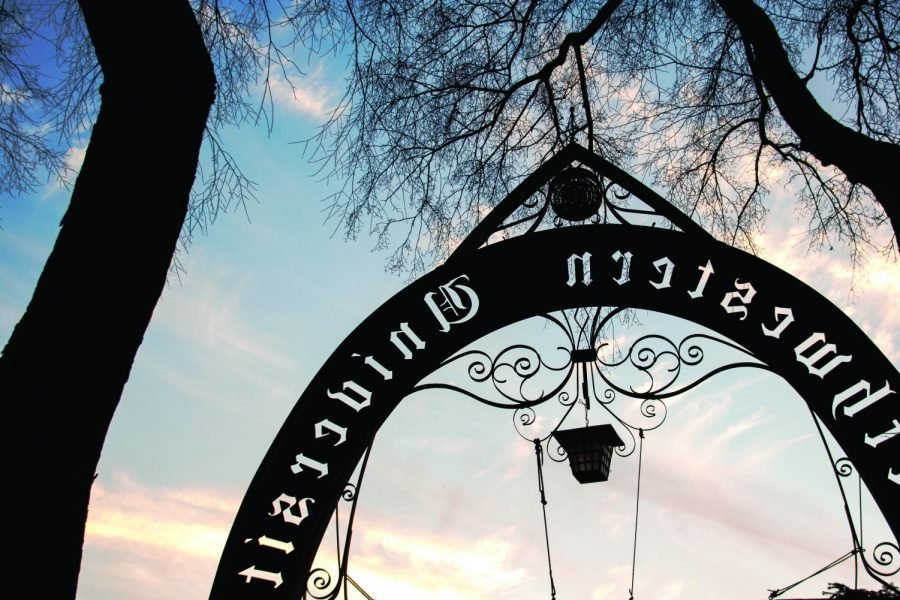 The silhouette of the Weber Arch with a sunset in the background.
