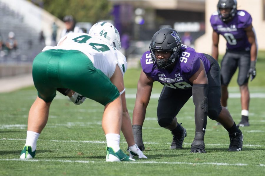 Adetomiwa Adebawore lines up against an Ohio player before the snap