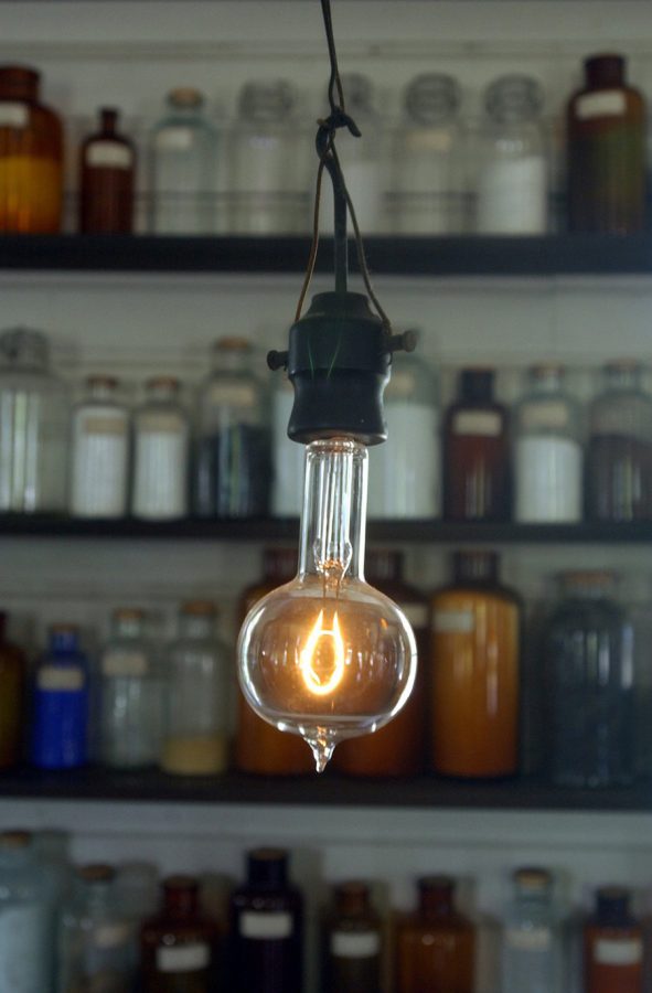 A single illuminated, industrial lightbulb hangs from the ceiling.