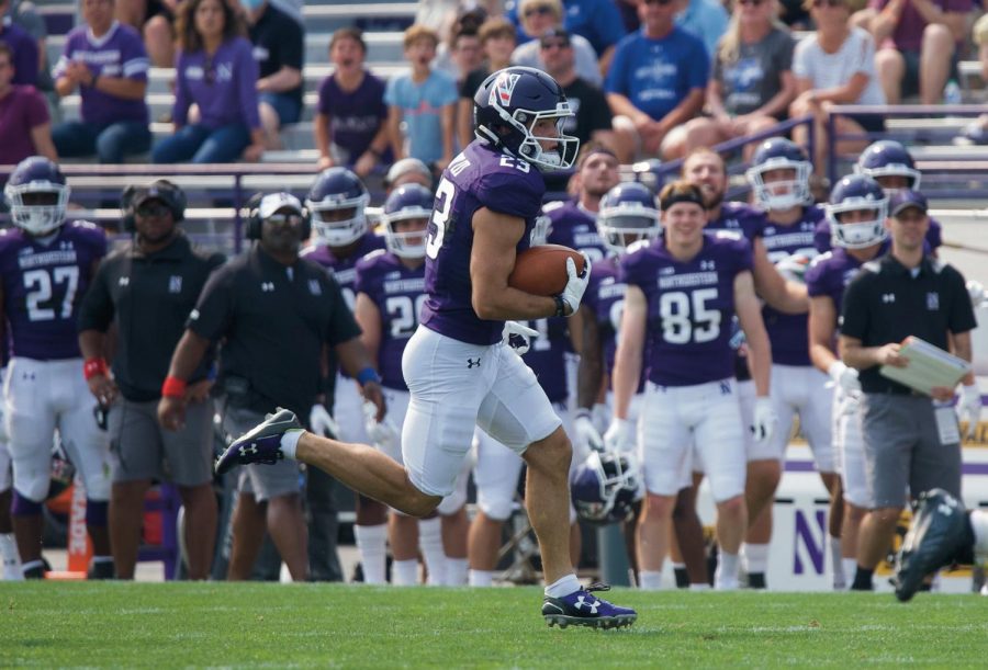A Northwestern player runs down the field with the ball on a punt return.