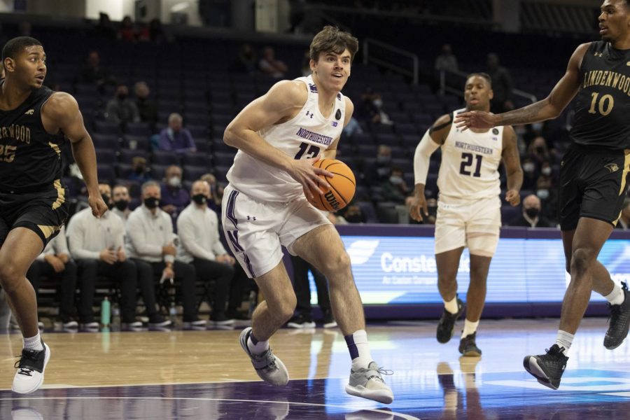 A Northwestern basketball player in a white jersey stares.