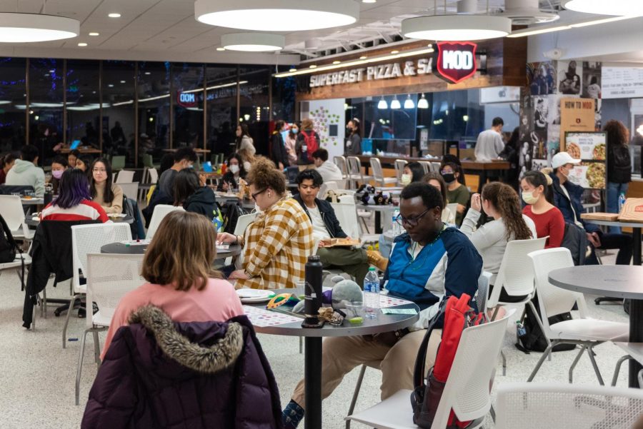 Students sit at circle tables at Mod in Norris University Center, some with and without masks.