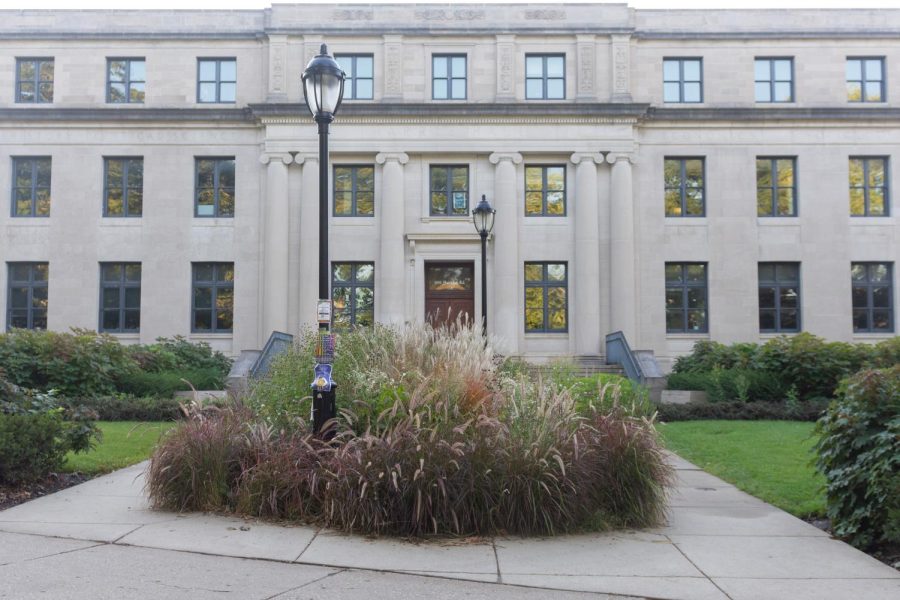 Harris Hall. A tan building with windows. Bushes are in the foreground and the sides.
