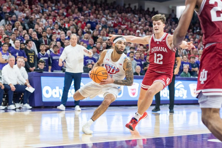 A basketball player in a white jersey dribbles the basketball.