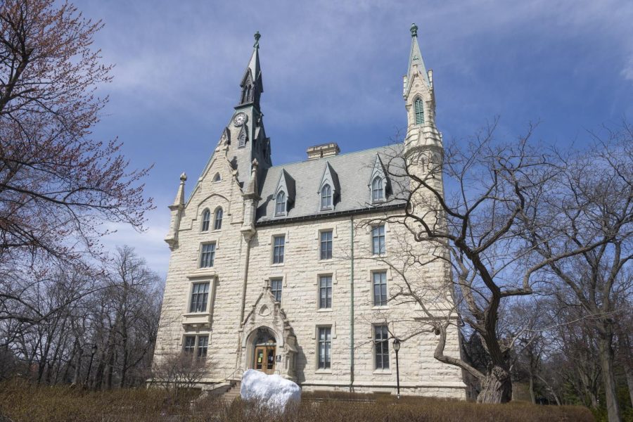 A large white building, surrounded by trees and with steps leading up to it.