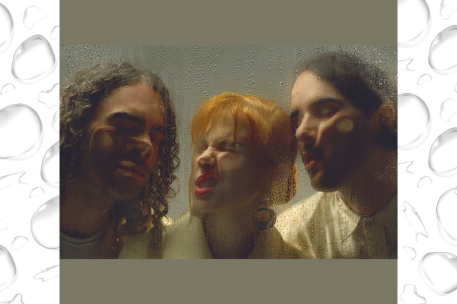 Three people press their faces up against a glass.