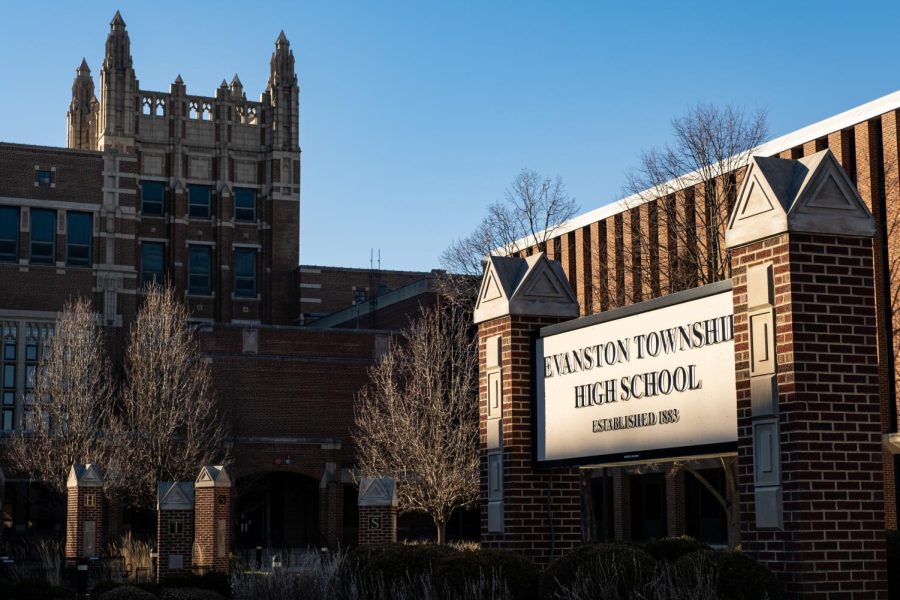 The front of a tall brick school building, with a sign reading "Evanston Township High School."