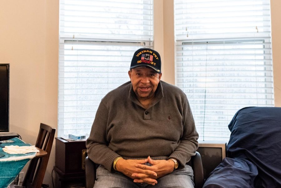 Kenneth Wideman, his hands folded in his lap, sits in a chair in front of a window.