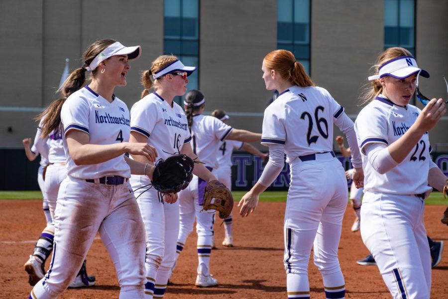 Four Northwestern softball players start walking off the field at Sharon J. Drysdale Field.