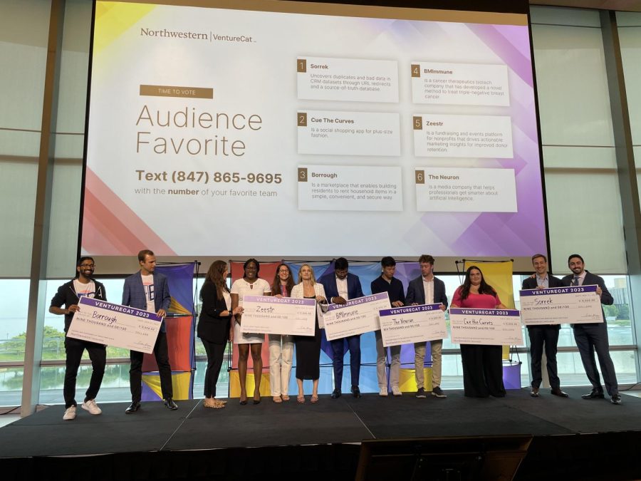 Six teams of finalists stand with big checks, totaling from $6,000 to $9,000 each.