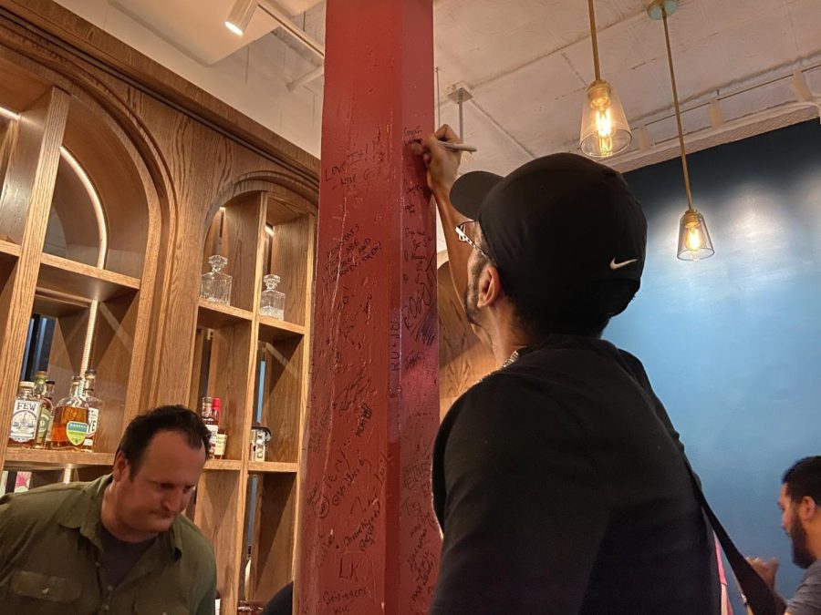 A man writes on a red pole
