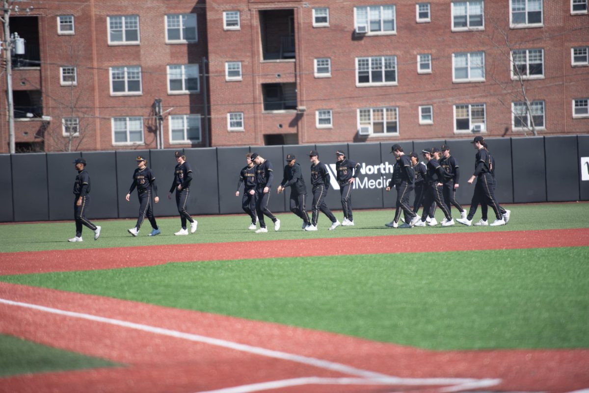 Northwestern players walk across the field. Many questions lie ahead for NU as it prepares for the 2024 season. 