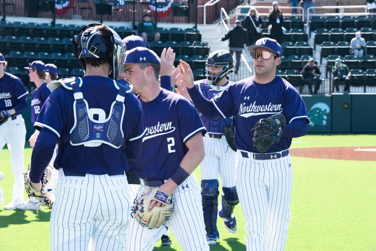Northwestern baseball players high-five at Tulane.
