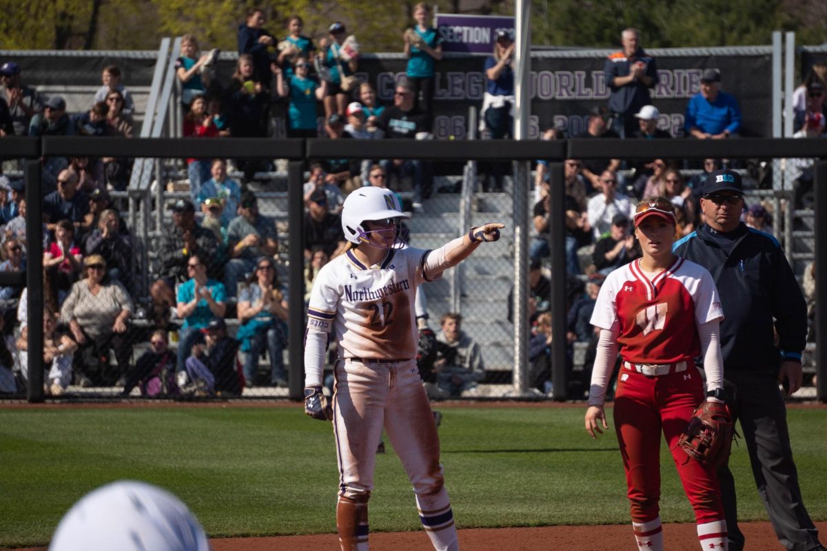 A player points towards her team after a base hit.