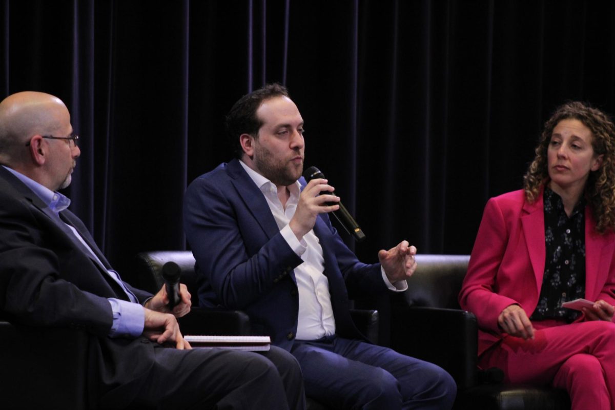 Dan Shapiro, Yair Rosenberg and Danielle Gilbert sit onstage from left to right as Rosenberg speaks.