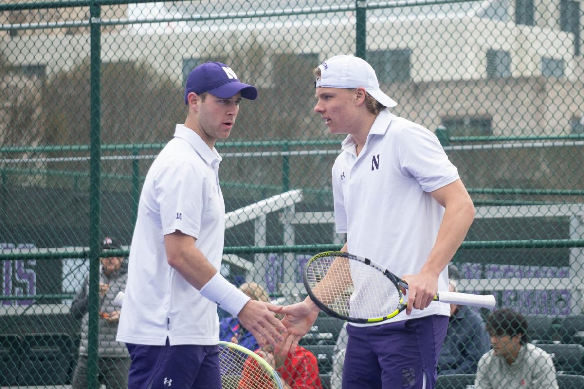 Senior Felix Nordby and junior Chad Miller high-five after winning a point. The two are 6-3 in their matches together this season, the most wins of any Northwestern doubles team this season.