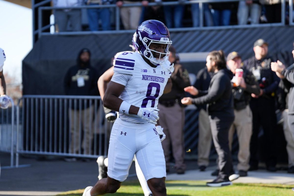 A.J. Henning runs onto the field before Northwestern’s game against Purdue last season. Henning signed a 3-year, $2.98 million contract with $150,000 guaranteed with the Miami Dolphins on Saturday.