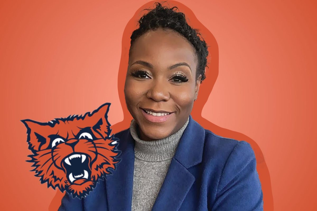 A wildcat mascot to the left of a woman in a blue blazer smiling to the camera on an orange background.