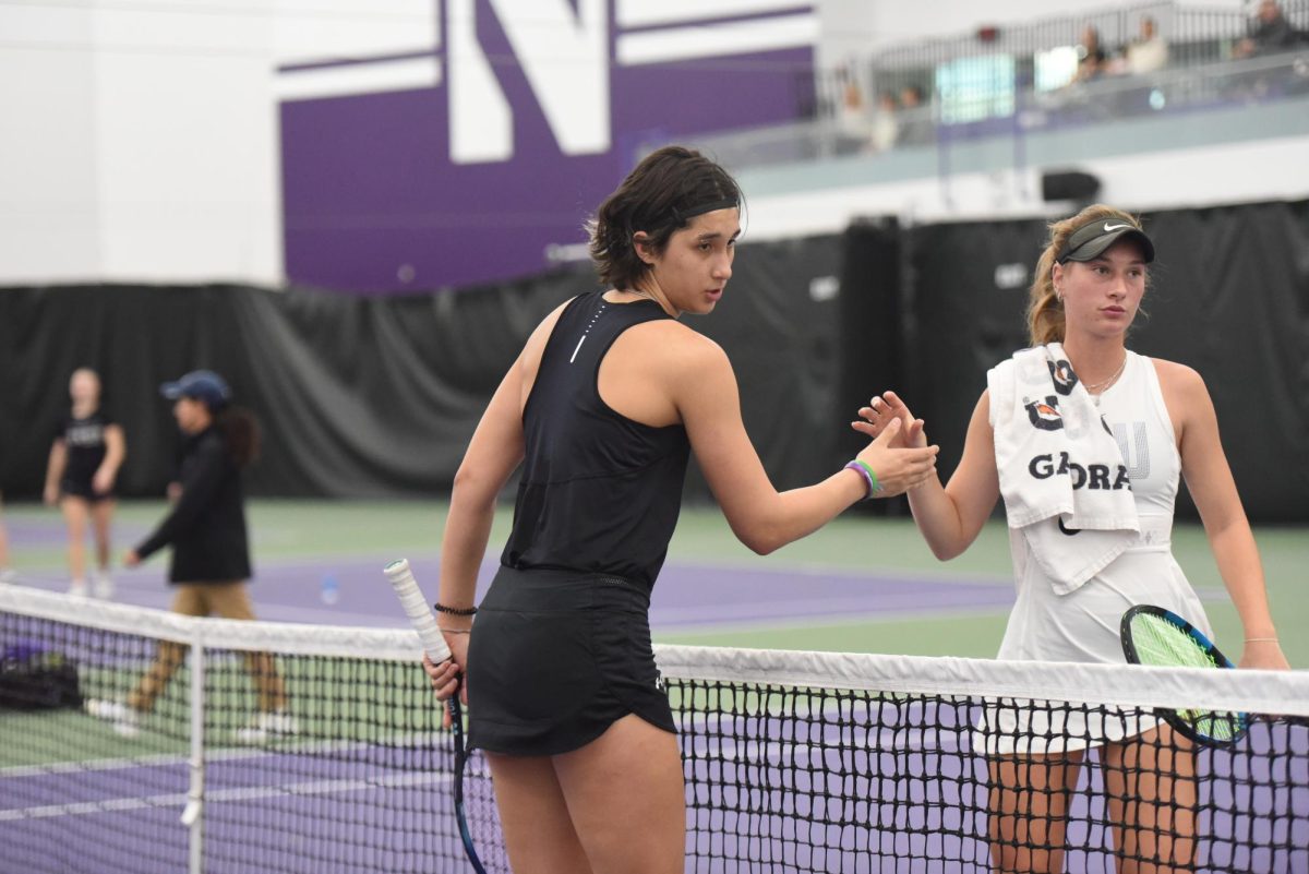 Freshman Erica Jessel approaches her opponent at the net for a handshake. Jessel paired up with senior Kiley Rabjohns at the No. 3 spot for the first time this season and won 6-2.