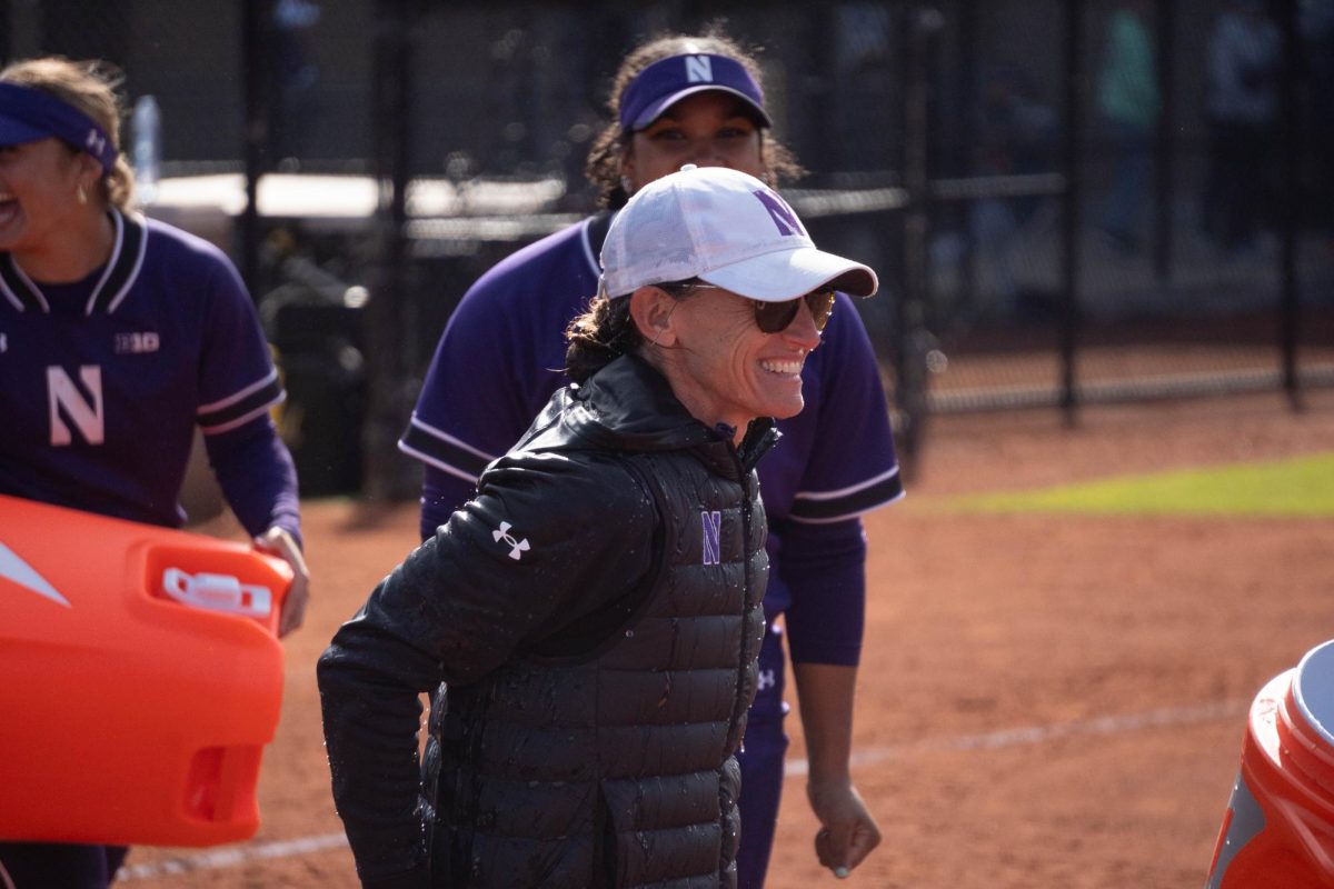 A woman smiles as Gatorade drips off her jacket. 