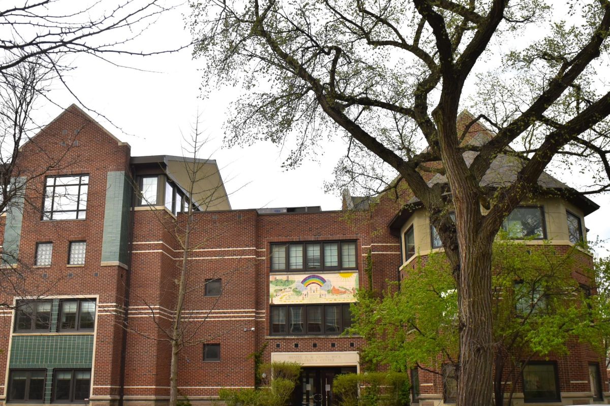 The outside of a brick building with a tree in the foreground.