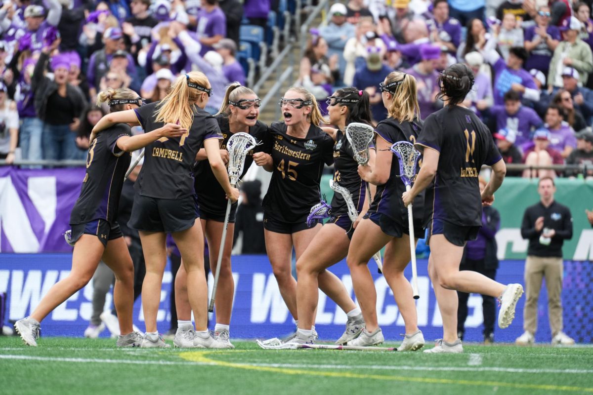 Northwestern lacrosse players wearing black huddle around each other.