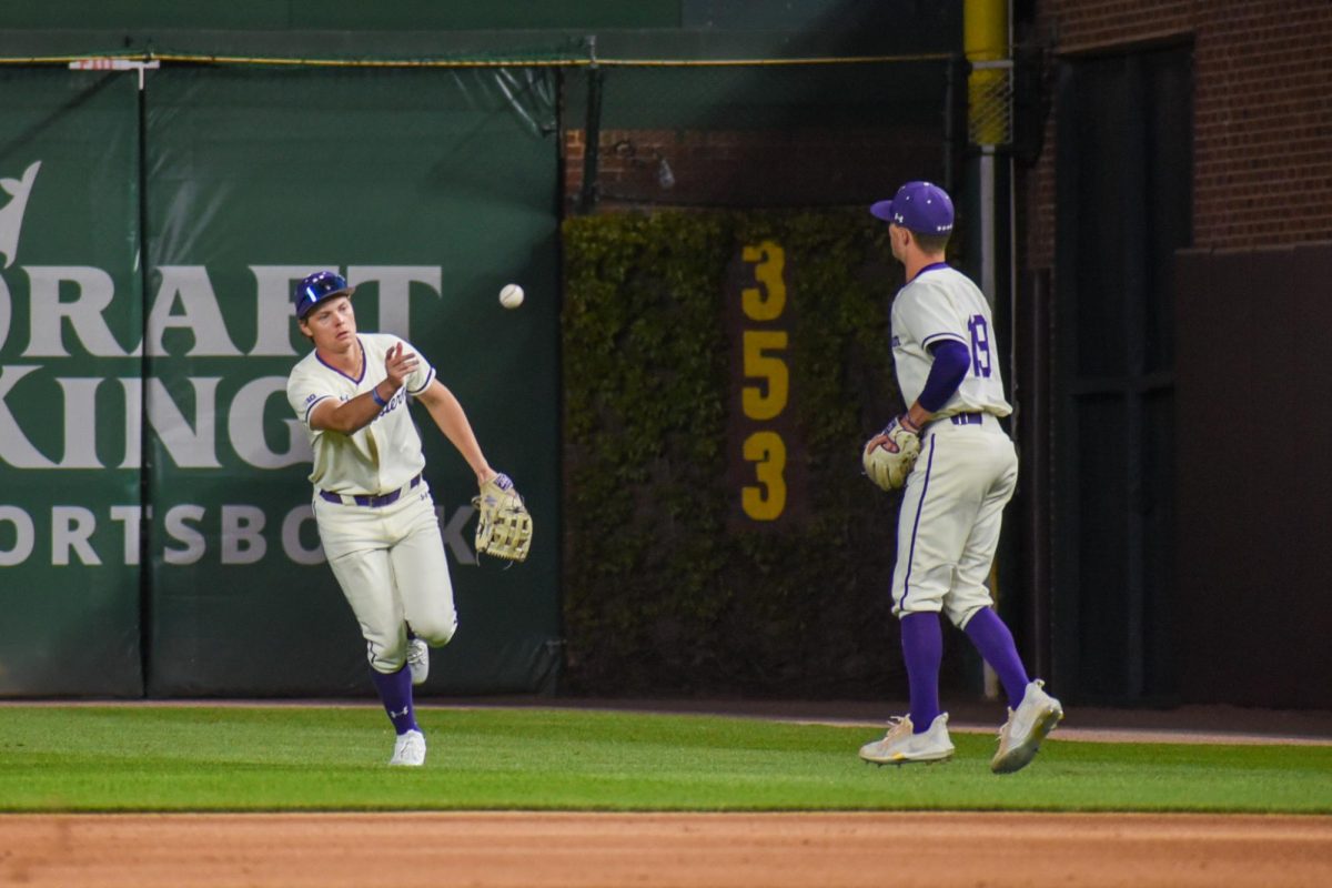 Two baseball players toss the ball to each other.