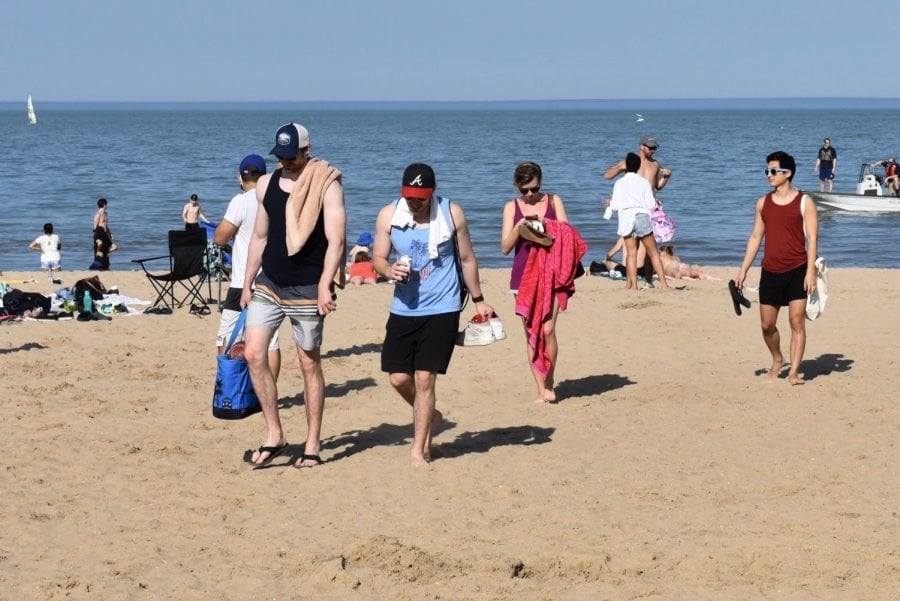 A group of people walks on the beach.