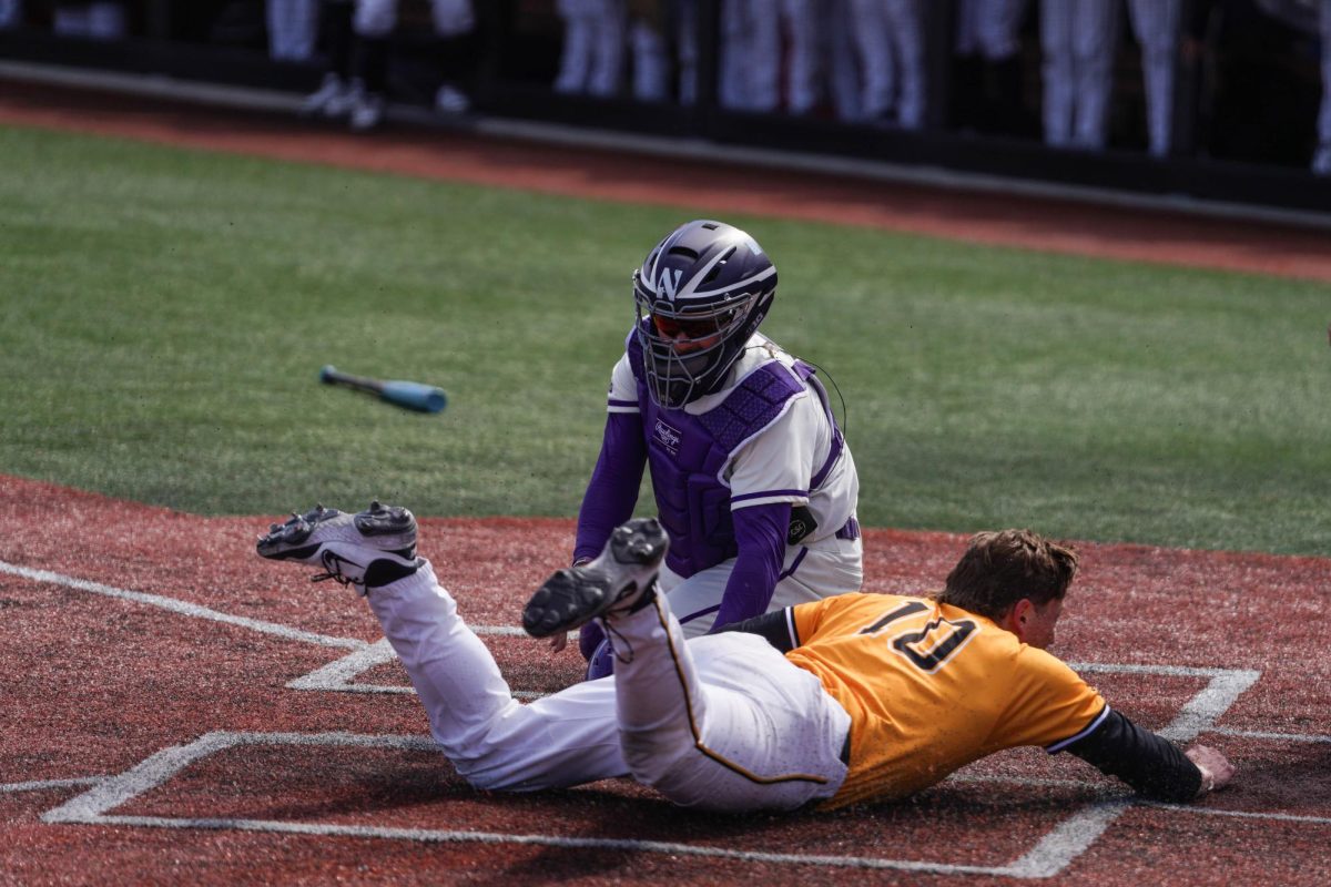 Senior catcher Bennett Markinson tags a runner at home plate against Iowa on April 6. Markinson went 4-of-11 in the series against Purdue this past weekend.