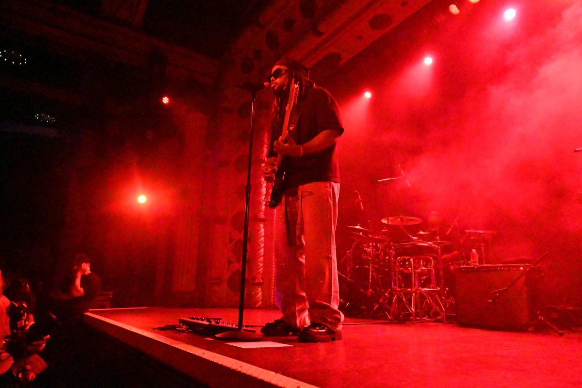 A person sings into a microphone while playing guitar