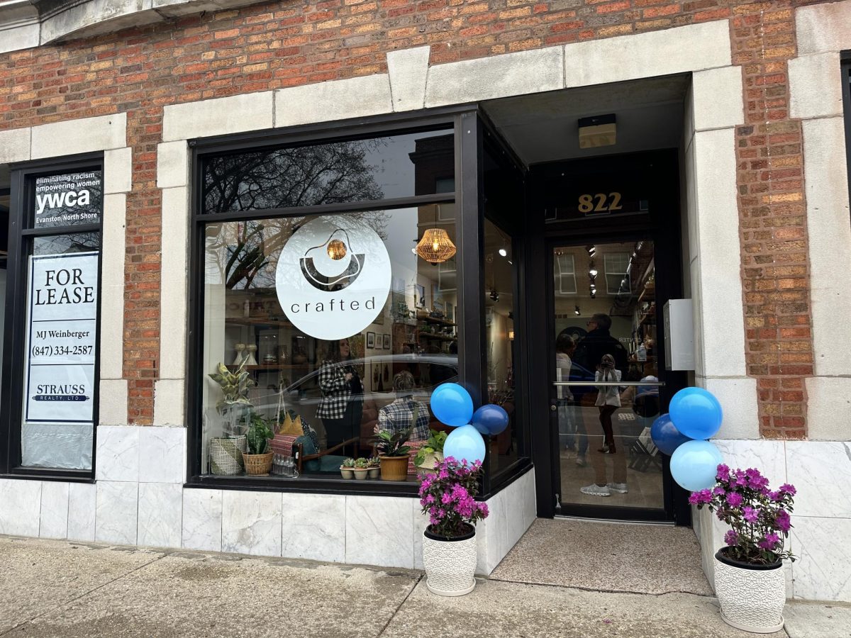 Storefront with a white circular logo in the window and people crowded inside the store.