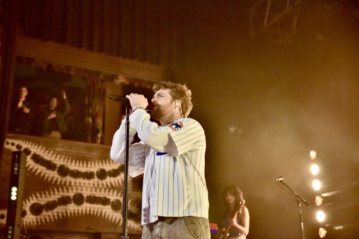 A man stands in front of a microphone singing.