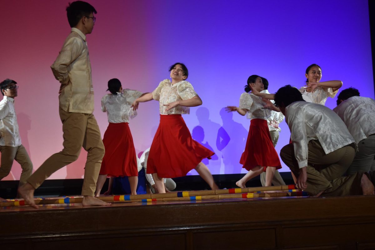 Some dancers move in a circular formation at the center while others surround them in an outer ring.